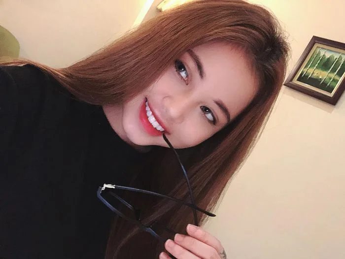 Gái xinh ngầu cười tươi cầm gọng kính