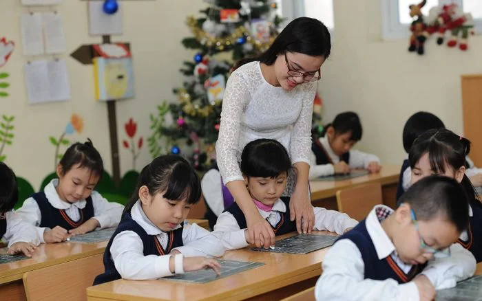 cô giáo hướng dẫn học sinh trong lớp học
