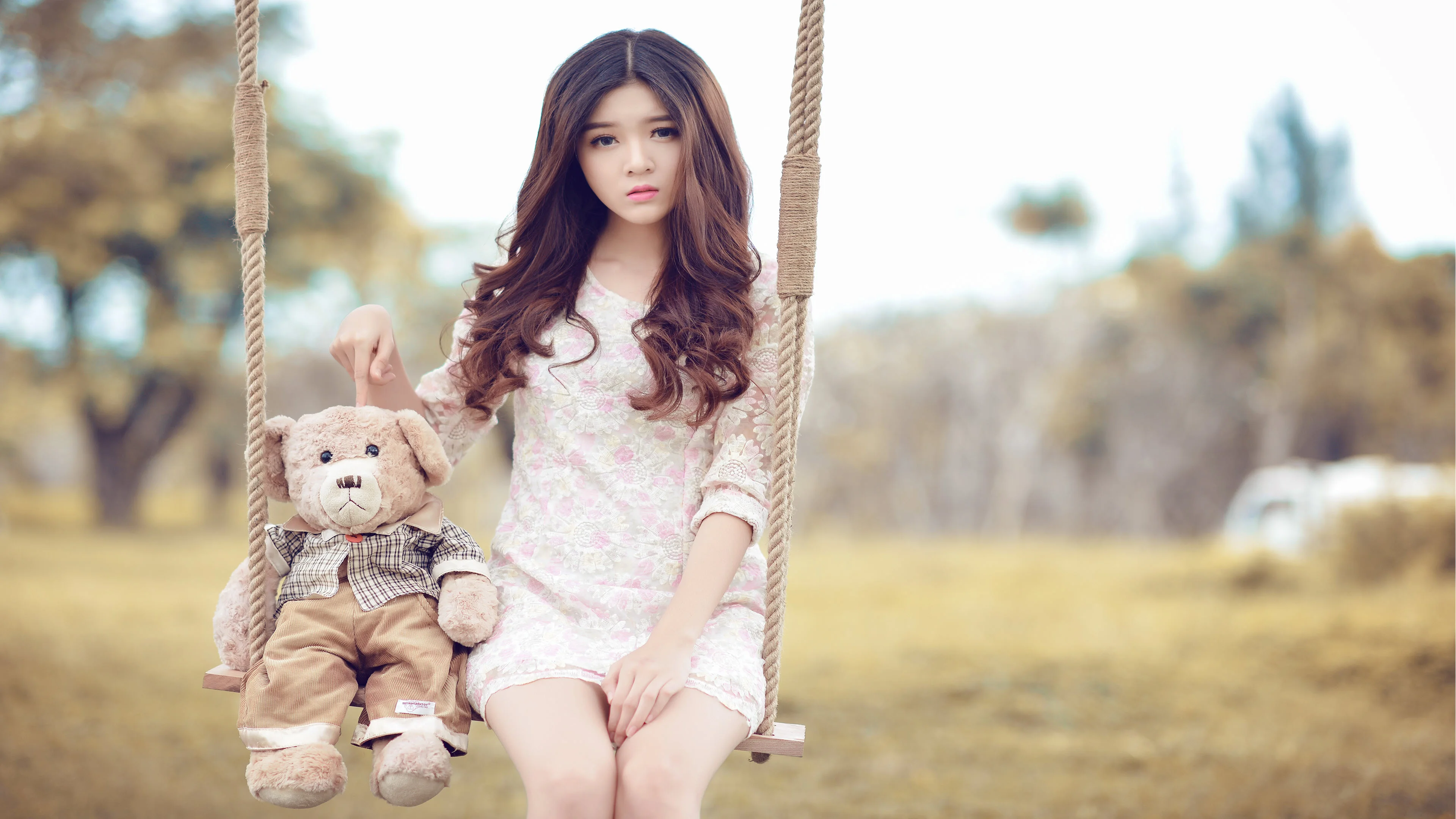 Hình gái xinh mặc váy trắng ngồi xích đu cùng gấu bông