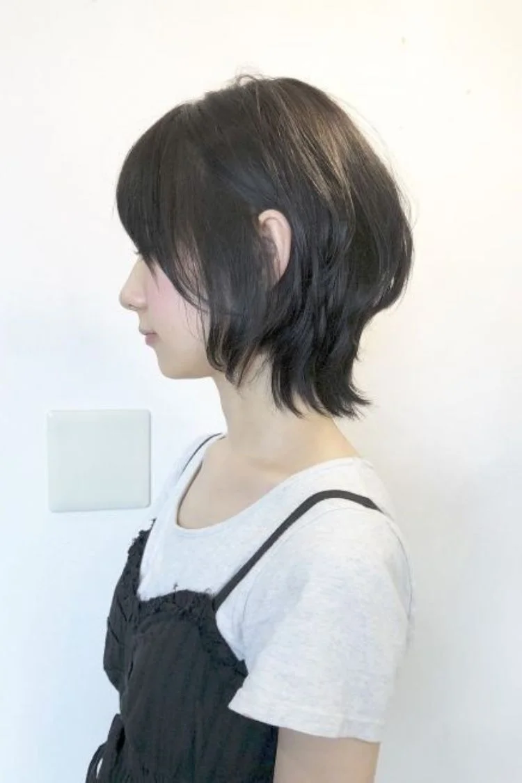 Góc nghiêng cô gái tóc mullet nữ đen ngắn, phần gáy tỉa gọn